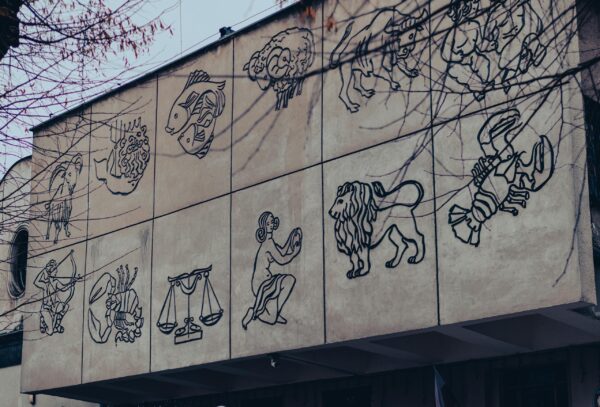Outdoor mural depicting zodiac signs on a building wall in Chrzanow, Poland.